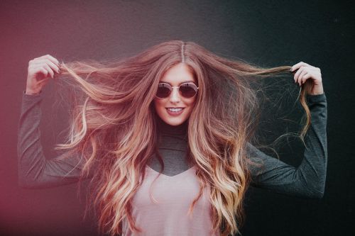 Ragazza spettinata con occhiali da sole