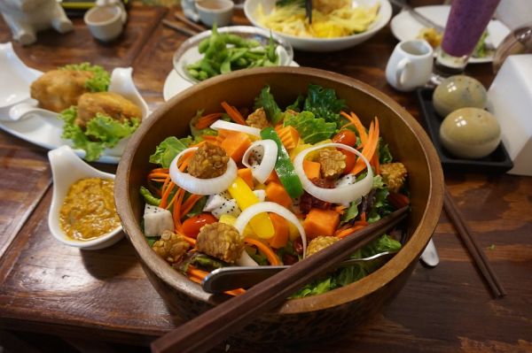 Insalata di verdure in una ciotola di bambu con bacchette