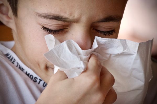 Bambino si soffia il naso in un fazzoletto