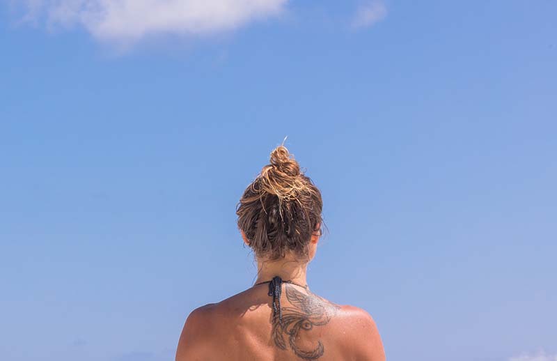 Ragazza in costume con tatuaggio sulla spalla