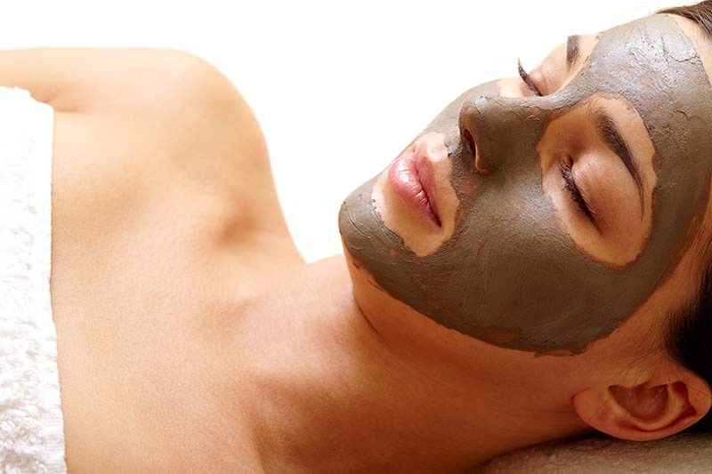 Donna si rilassa con una maschera di fango sul viso