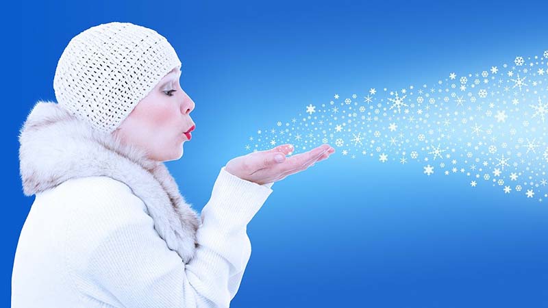 Donna che soffia fiocchi di neve
