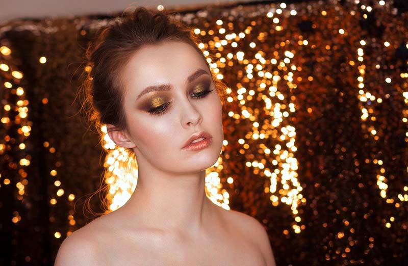 Donna elegante con trucco dorato