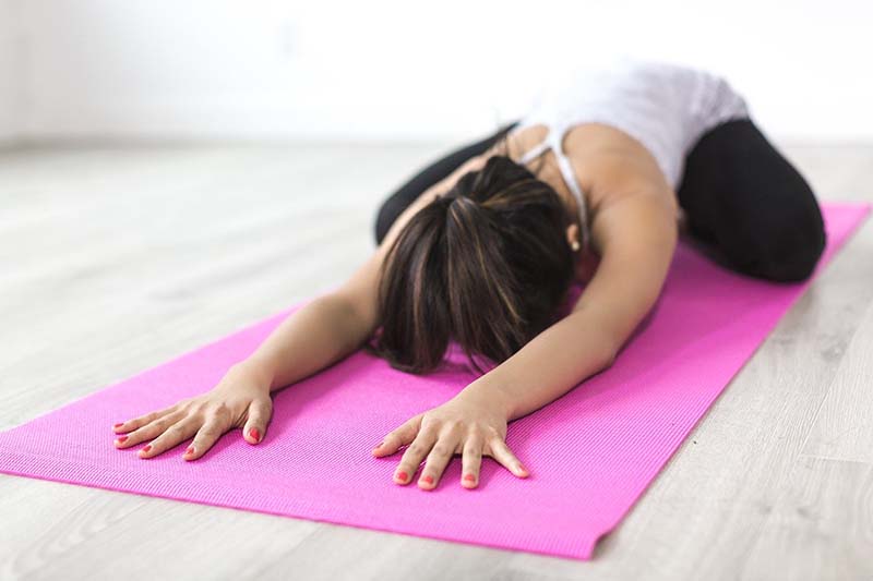 Donna fa yoga sul tappetino