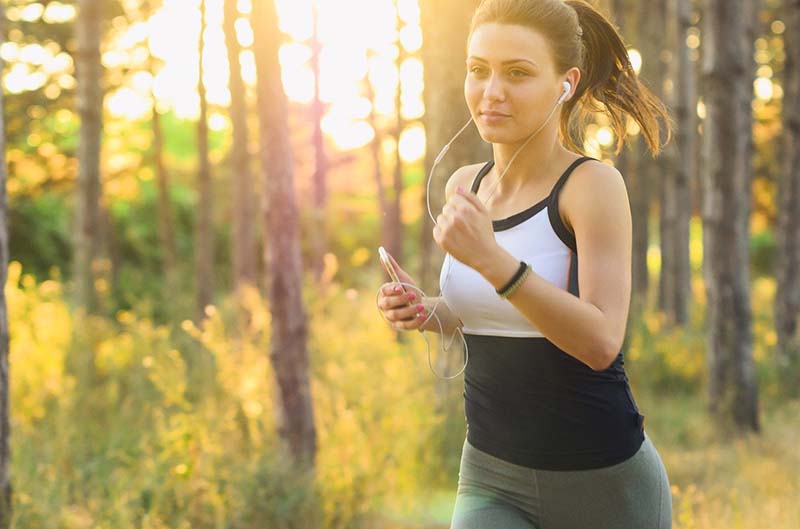 Donna che corre in un bosco