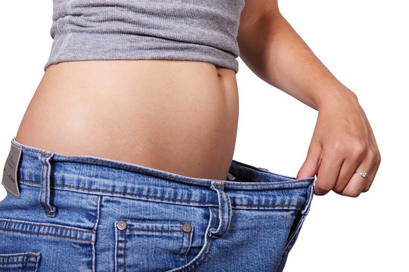 Donna che ha perso peso con dieta indossa jeans largo