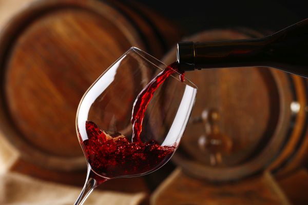 Vino rosso viene versato in un calice