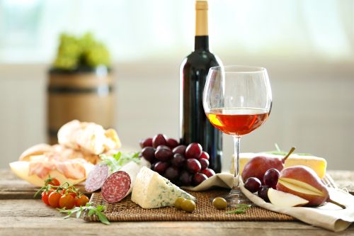 Calice di vino con tagliere di salumi, formaggi e frutta