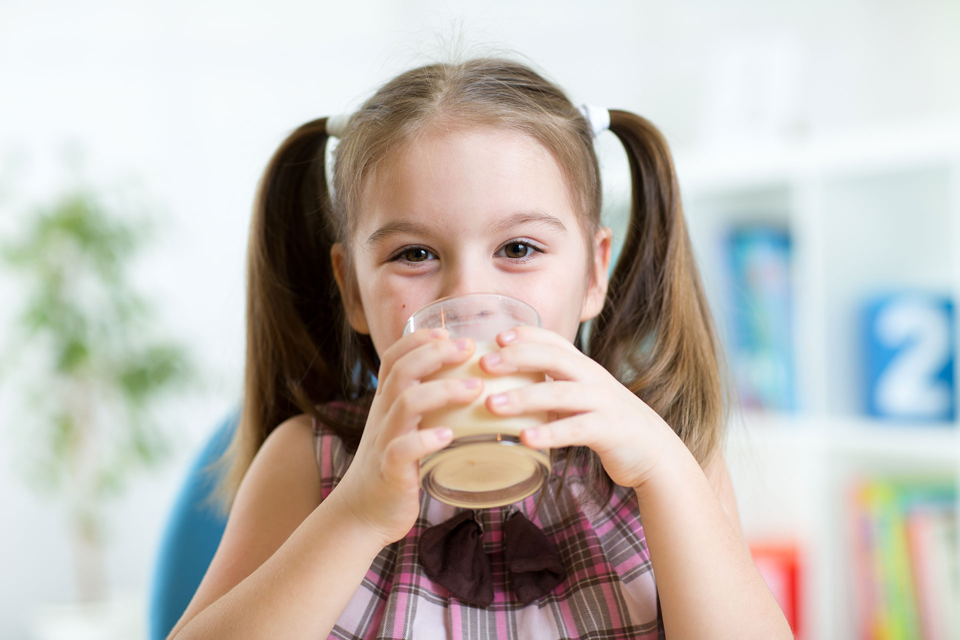 Bambina che beve un bicchiere di latte